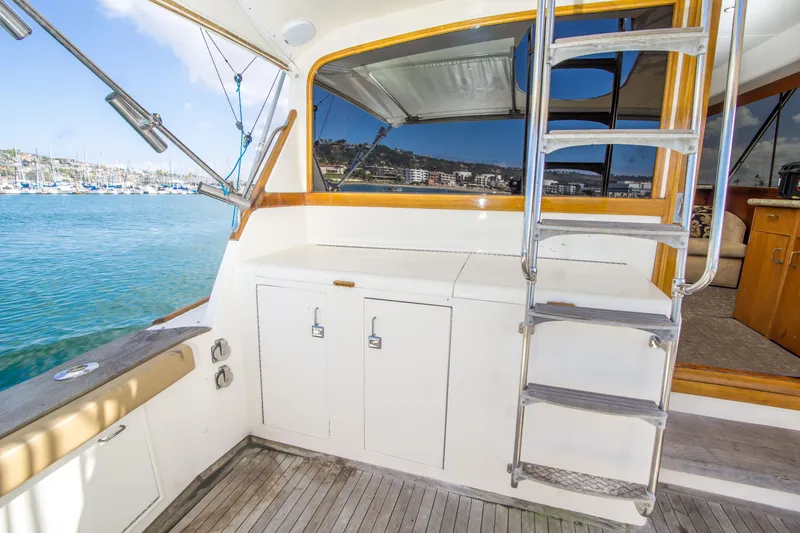 Slide: The Image of 1986 Ocean Yachts 48 Super Sport yacht deck with ladder and marina view. - 9