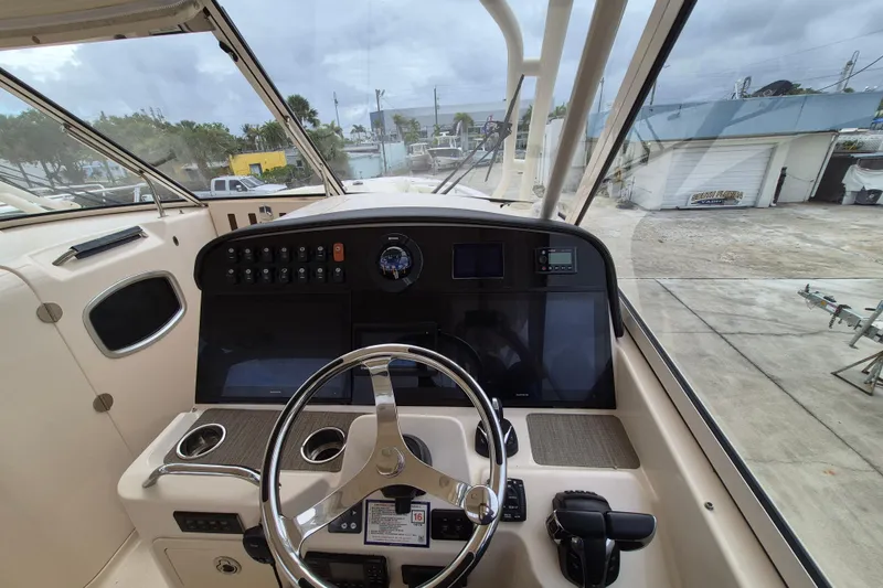 Slide: The Image of 2022 Grady-White Freedom 335 boat helm with steering wheel and control panel. - 12