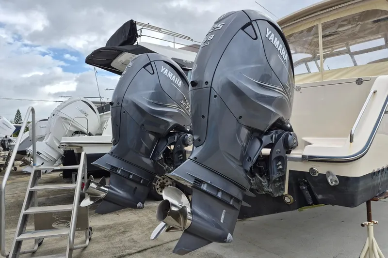 Slide: The Image of 2022 Grady-White Freedom 335 with dual Yamaha outboard motors, docked under cloudy skies. - 3