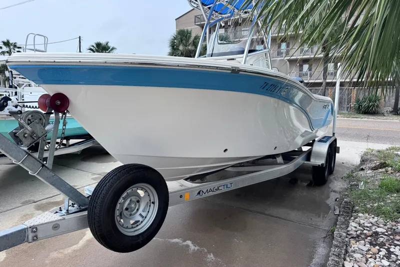 Slide: The Image of 2018 Sea Fox 206 Commander boat on trailer, parked near palm trees. - 2