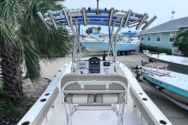 Slide: The Image of 2018 Sea Fox 206 Commander boat with T-top and console, docked near palm trees. - 34