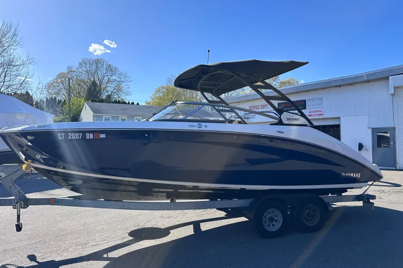 Slide: The Image of 2021 Yamaha Boats 252SD on trailer, parked outdoors under clear blue sky. - 5