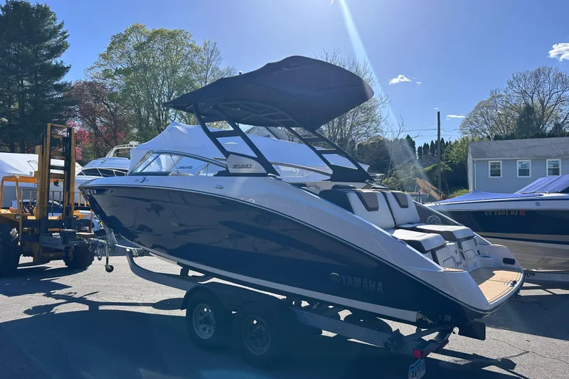 Slide: The Image of 2021 Yamaha Boats 252SD on trailer, parked outdoors under clear sky. - 6