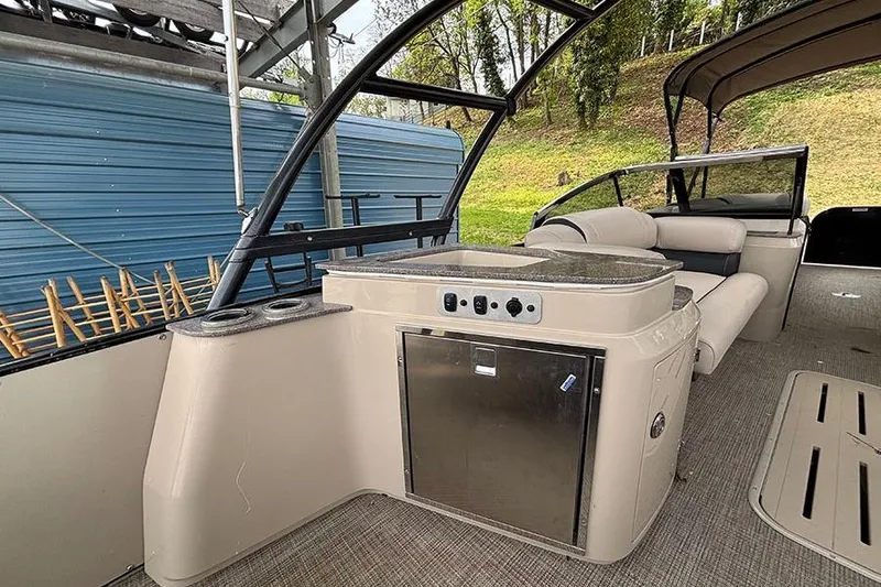 Slide: The Image of 2017 Avalon Ambassador Elite Windshield boat interior with seating and kitchenette. - 11