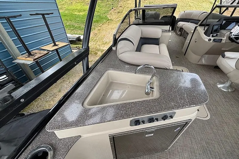 Slide: The Image of Luxurious interior of 2017 Avalon Ambassador Elite Windshield boat with seating and kitchenette. - 14