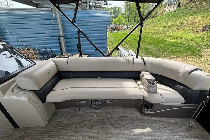 Slide: The Image of 2017 Avalon Ambassador Elite Windshield boat interior with beige seating and cup holders. - 22