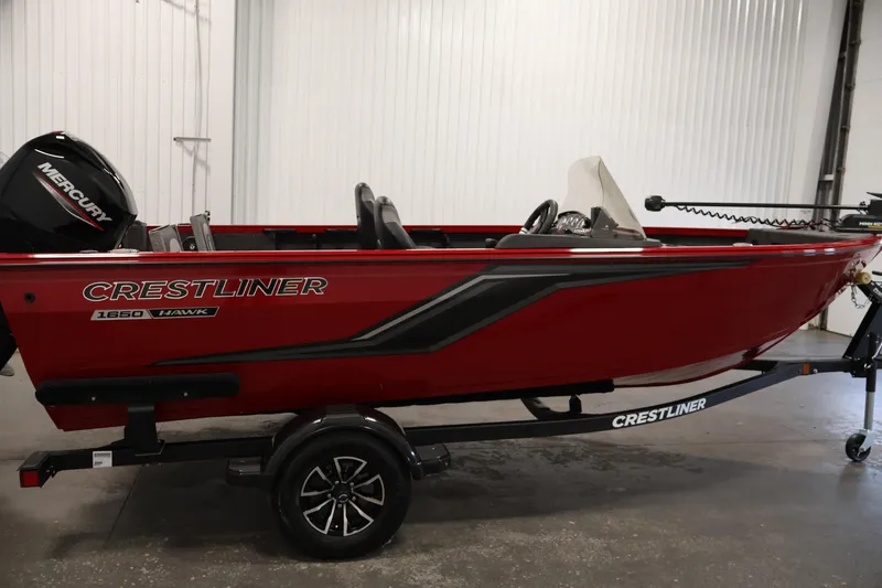 Slide: The Image of 2026 Crestliner 1650 HAWK SC fishing boat in red, side view in a showroom. - 8