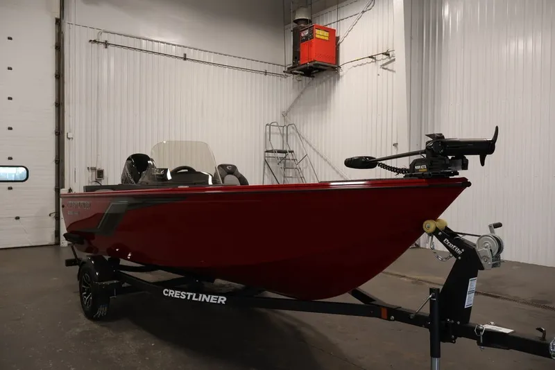 Slide: The Image of 2026 Crestliner 1650 Hawk SC boat in a garage, red exterior, on a trailer. - 13