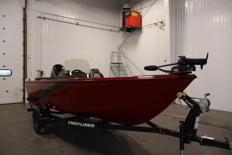 Slide: The Image of 2026 Crestliner 1650 HAWK SC boat in a garage, featuring a sleek red design. - 7