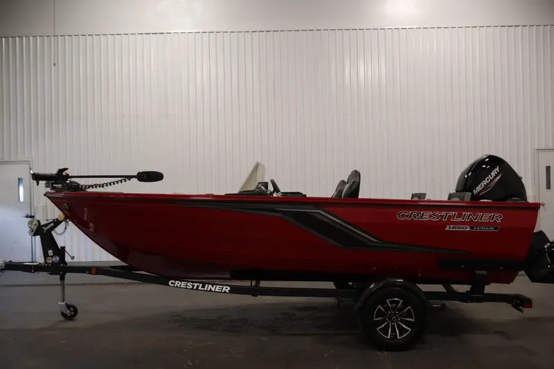 Slide: The Image of 2026 Crestliner 1650 HAWK SC fishing boat in vibrant red, displayed indoors. - 12