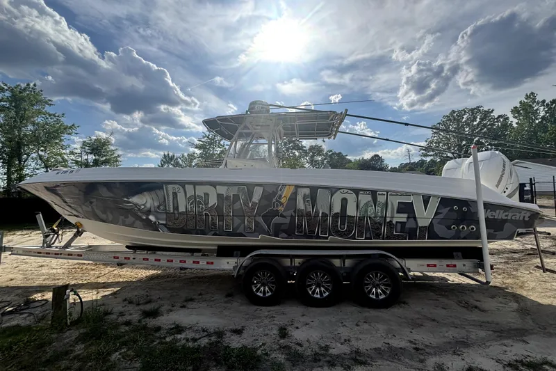 The Image of 2005 Wellcraft 35 Scarab Tournament boat with "Dirty Money" graphics on a trailer. - 1