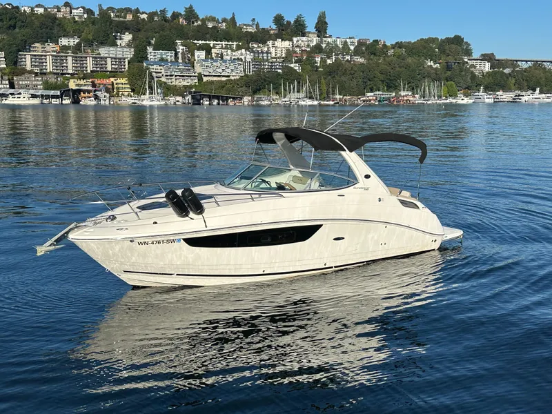 The Image of 2015 Sea Ray Sundancer 280 on calm water near coastal city. - 0