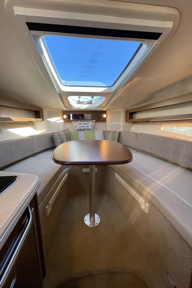 Slide: The Image of Interior of a 2015 Sea Ray Sundancer 280 with table and seating area. - 16
