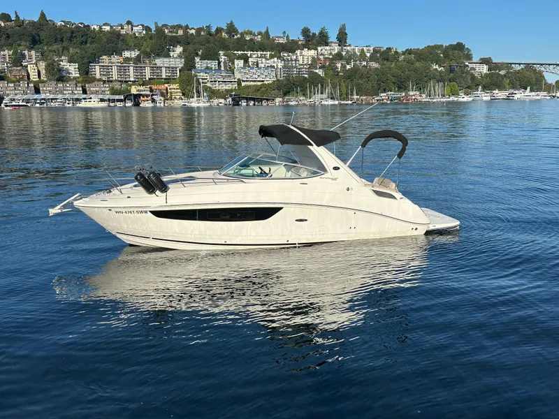 Slide: The Image of 2015 Sea Ray Sundancer 280 on calm water near coastal city. - 2