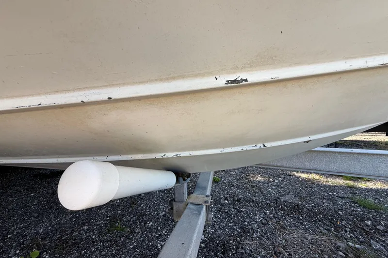 Slide: The Image of 2000 Sport-Craft 241 Walk Around boat hull with visible wear on trailer. - 100