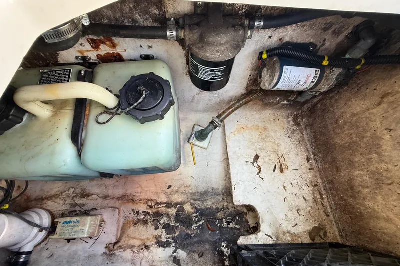 Slide: The Image of Engine compartment of a 2000 Sport-Craft 241 Walk Around boat, showing fuel and filter components. - 104