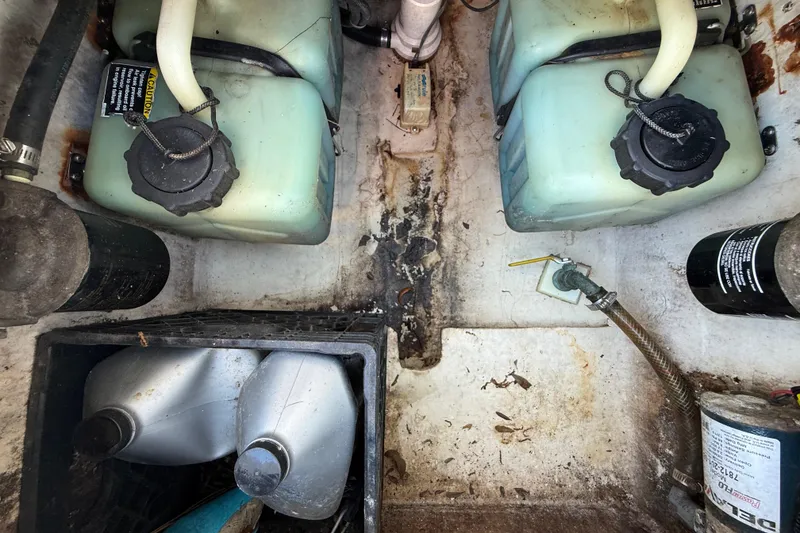 Slide: The Image of Boat engine compartment of 2000 Sport-Craft 241 Walk Around with fuel tanks and oil containers. - 105