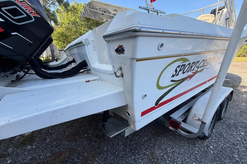 Slide: The Image of 2000 Sport-Craft 241 Walk Around boat on trailer, featuring Mercury engine. - 12