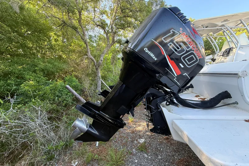 Slide: The Image of Outboard motor on 2000 Sport-Craft 241 Walk Around boat, surrounded by greenery. - 14