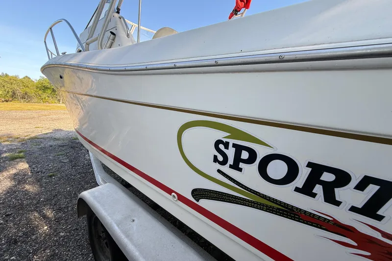 Slide: The Image of 2000 Sport-Craft 241 Walk Around boat on trailer, side view with logo visible. - 22
