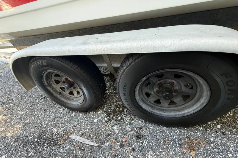 Slide: The Image of Trailer wheels of a 2000 Sport-Craft 241 Walk Around boat on gravel surface. - 23