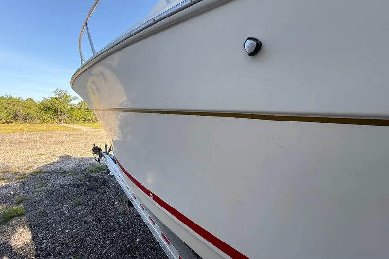 Slide: The Image of 2000 Sport-Craft 241 Walk Around boat on trailer, side view, outdoors. - 25