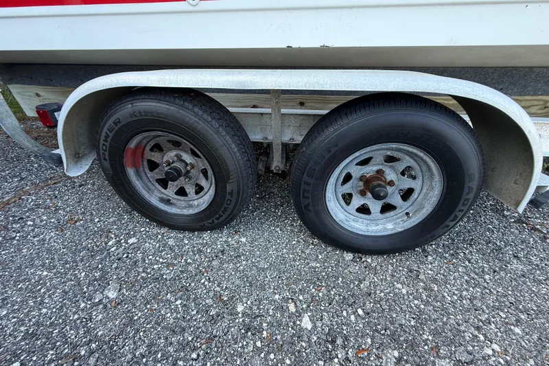 Slide: The Image of Trailer wheels of a 2000 Sport-Craft 241 Walk Around boat on gravel surface. - 29