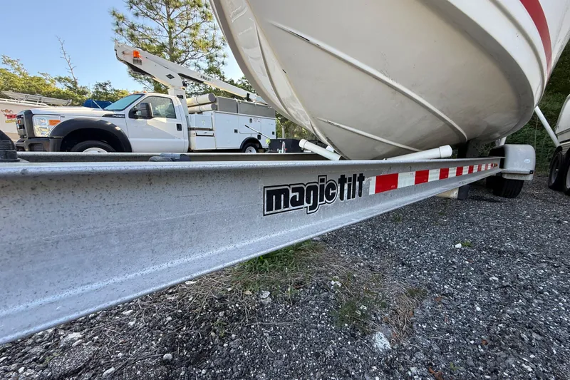 Slide: The Image of 2000 Sport-Craft 241 Walk Around boat on Magic Tilt trailer, parked near utility truck. - 36