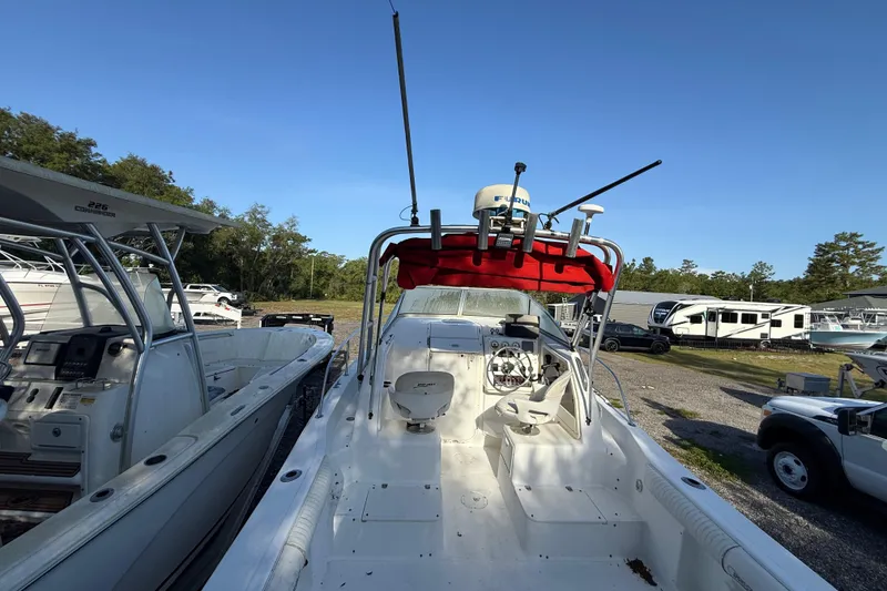 Slide: The Image of 2000 Sport-Craft 241 Walk Around boat with red canopy, parked outdoors. - 44
