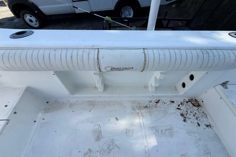 Slide: The Image of 2000 Sport-Craft 241 Walk Around boat interior with white seating and storage area. - 45