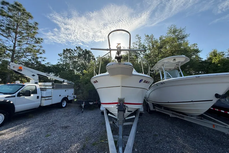 Slide: The Image of 2000 Sport-Craft 241 Walk Around boat on trailer, parked beside a utility truck. - 5