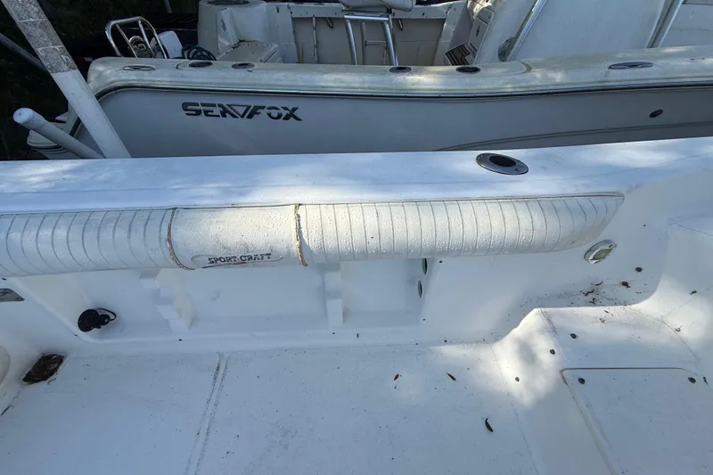 Slide: The Image of 2000 Sport-Craft 241 Walk Around boat interior with visible seating and deck details. - 50