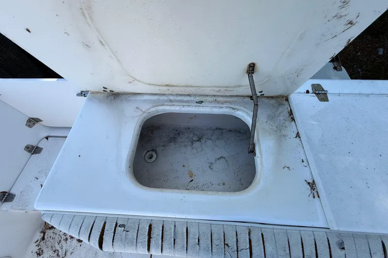 Slide: The Image of Open storage compartment on 2000 Sport-Craft 241 Walk Around boat, showing wear and dirt. - 54