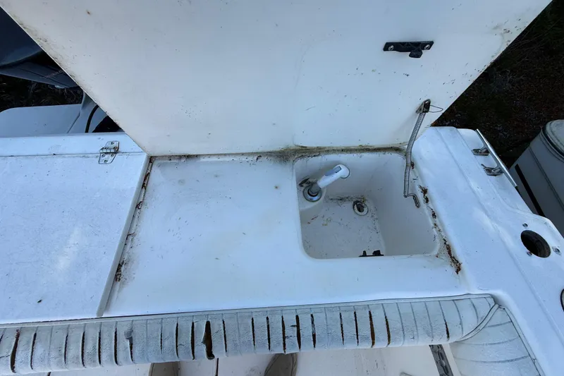 Slide: The Image of Sport-Craft 241 Walk Around 2000 boat sink area with open lid and visible wear. - 55
