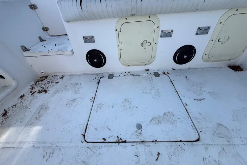 Slide: The Image of 2000 Sport-Craft 241 Walk Around boat interior with storage compartments and speakers. - 56