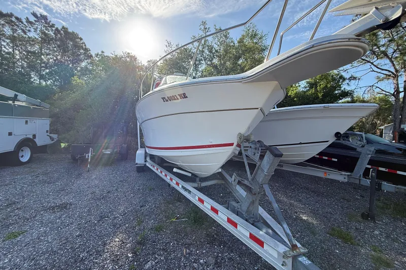 Slide: The Image of 2000 Sport-Craft 241 Walk Around boat on trailer, parked outdoors under sunlight. - 6