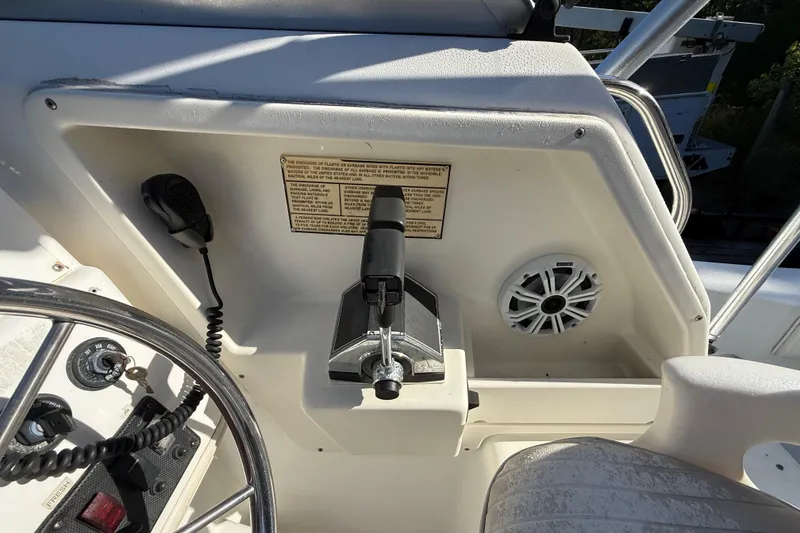 Slide: The Image of Control panel of a 2000 Sport-Craft 241 Walk Around boat with steering wheel and throttle. - 60