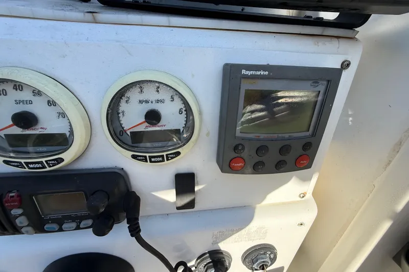 Slide: The Image of Instrument panel of a 2000 Sport-Craft 241 Walk Around boat with gauges and Raymarine display. - 62