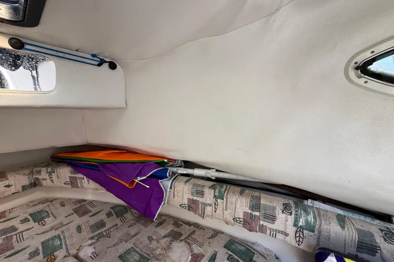 Slide: The Image of Interior of a 2000 Sport-Craft 241 Walk Around boat with colorful umbrella stored. - 67