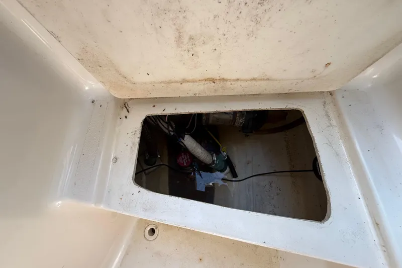 Slide: The Image of Open hatch of 2000 Sport-Craft 241 Walk Around boat, showing interior compartment. - 70