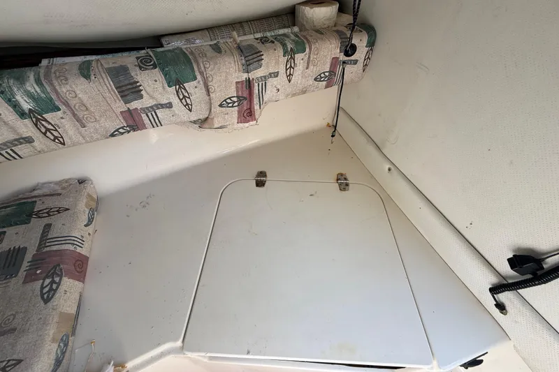 Slide: The Image of Interior of a 2000 Sport-Craft 241 Walk Around boat with patterned cushions. - 71