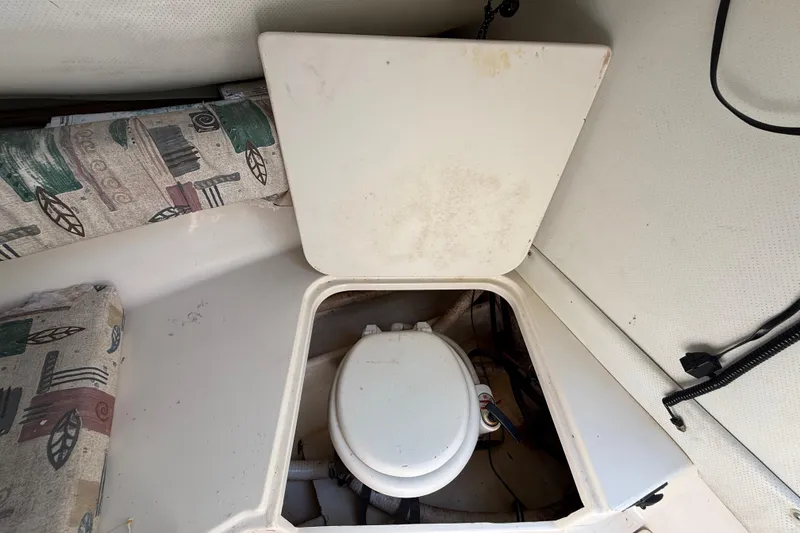 Slide: The Image of 2000 Sport-Craft 241 Walk Around boat interior with open hatch revealing toilet. - 72