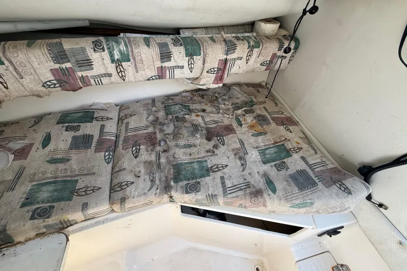 Slide: The Image of Worn interior cushions of a 2000 Sport-Craft 241 Walk Around boat, showing signs of damage. - 74