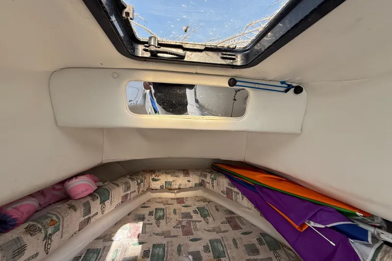 Slide: The Image of Interior cabin of 2000 Sport-Craft 241 Walk Around boat with colorful cushions and window. - 80