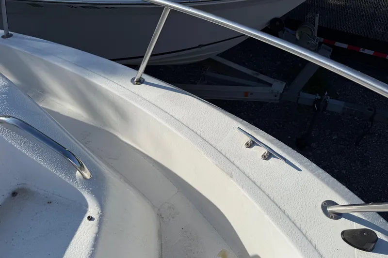 Slide: The Image of 2000 Sport-Craft 241 Walk Around boat deck with railing and cleat in sunlight. - 86