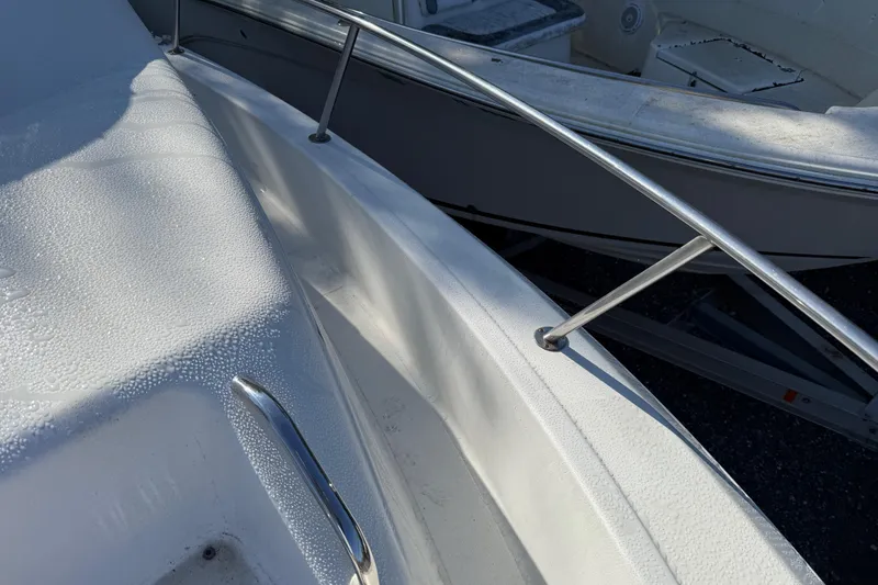 Slide: The Image of 2000 Sport-Craft 241 Walk Around boat deck with stainless steel railing and morning dew. - 87