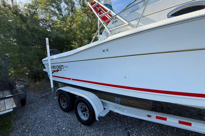 Slide: The Image of 2000 Sport-Craft 241 Walk Around boat on trailer, parked outdoors. - 9