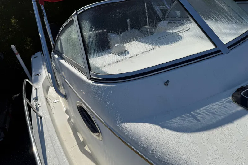 Slide: The Image of 2000 Sport-Craft 241 Walk Around boat with dew-covered windshield and sleek design. - 93