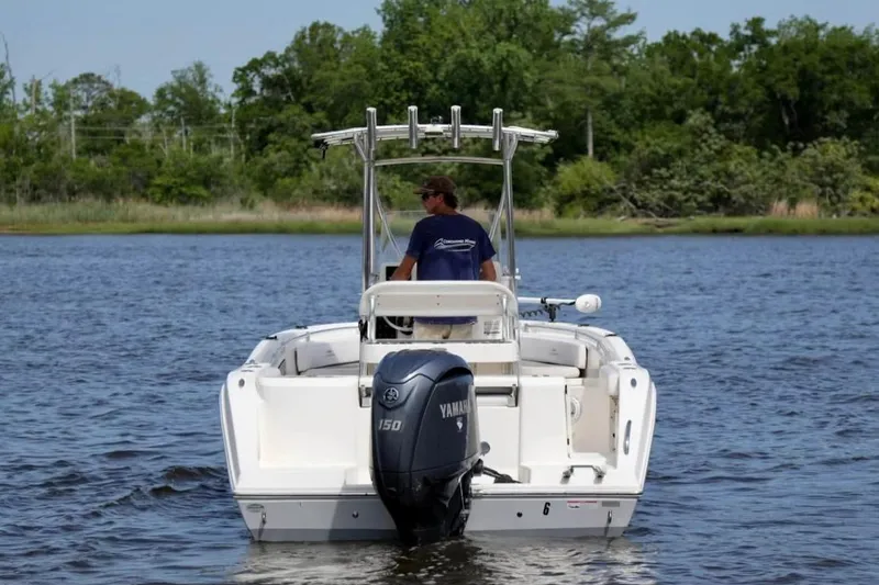Slide: The Image of 2019 Cobia 220 Center Console boat with Yamaha engine on a calm lake. - 4