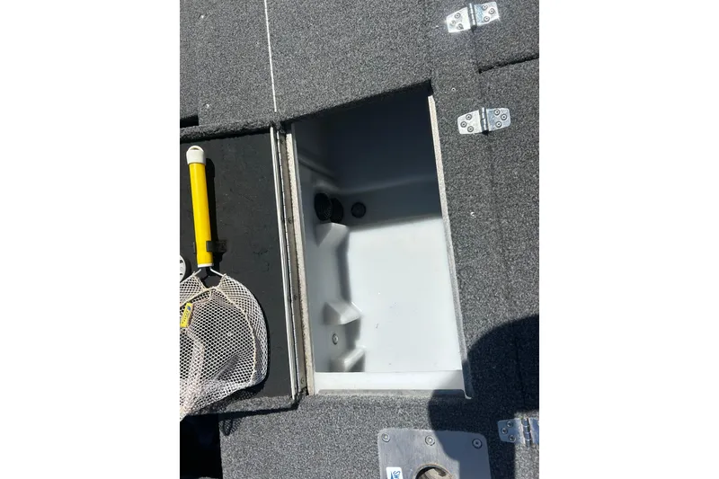 Slide: The Image of 2021 Lund 2075 Pro-V Limited boat storage compartment with fishing net and yellow handle. - 19